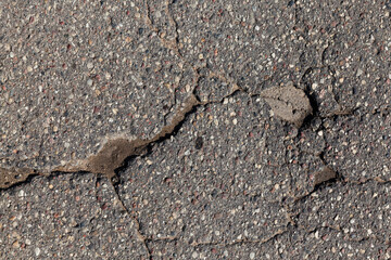 an asphalt road with a lot of holes and potholes