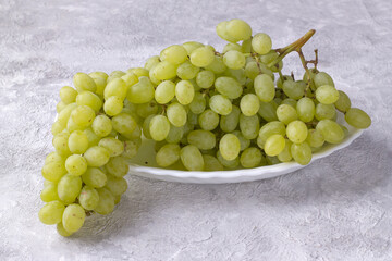 Bunch of white sweet grapes on a light background