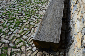 wooden massive park bench shape block on granite natural cobblestone irregular chipped brown gray...