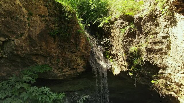 Drone view of a waterfall in Tipova, Moldova. Cave and greenery