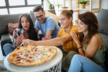 Cheerful group of friends having fun at home,eating pizza.
