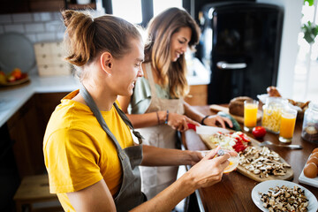 Portrait of happy young couple cooking together in the kitchen at home.