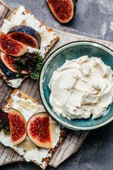 Bowl of philadelphia cream cheese and fresh figs. vertical image. top view