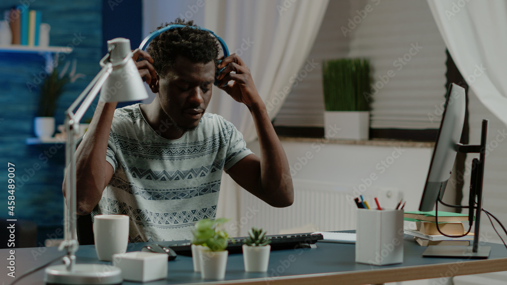 Aufkleber enrepreneur typing on keyboard and listening to music, working from home. person wearing headphones 