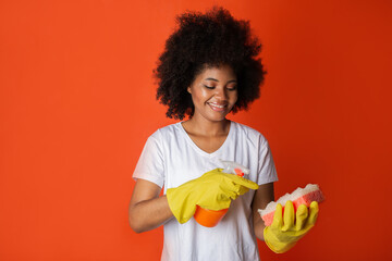 cleaning with spray and cleaning agent african female on red background 