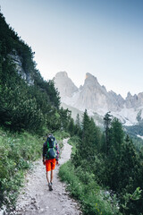 Fototapeta na wymiar Young dad with baby boy travelling with backpack. Father on hiking adventure with child, family trip in mountains. Vacations journey with infant, Dolomites, Italy