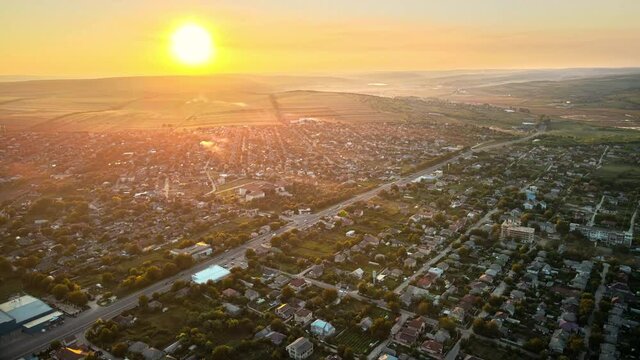 Aerial drone view of Tipova, Moldova at sunset. Road with cars, residential buildings, greenery