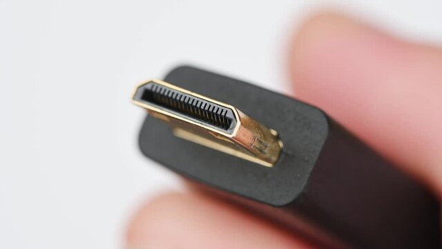 Close up of HDMI display monitor connector system or connection interface in hand isolated on white background. Display transfer information for digital camera gadget smartphone or laptop.