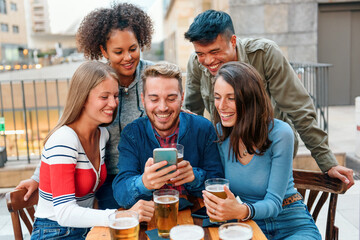 Group of diverse young friends gathered around a smartphone