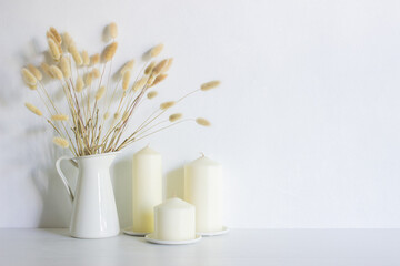 Candles with flowers on a white table with nature light. 