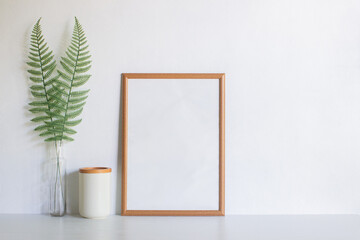 A brown blank frame with fern over the white background. 
