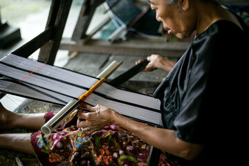 Close up Picture of tradition makes yarn with a spindle wheel at traditional Sasak village, Sasak...