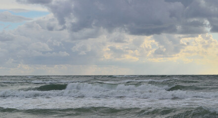Naklejka na ściany i meble seascape: the sea during a storm, high waves rise, clouds hang over the water