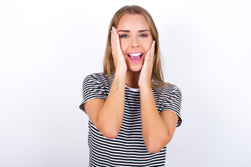 Fototapeta premium beautiful blonde girl wearing striped t-shirt on white background Pleasant looking cheerful, Happy reaction