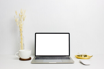 Mock up computer with coffee and flowers over light background. 
