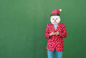 Anonymous person dressed in christmas clothes using a red mobile