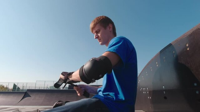 Man puts on wrist protection outdoors