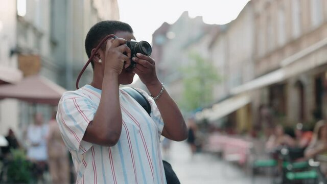 African woman taking photos of old city in retro camera