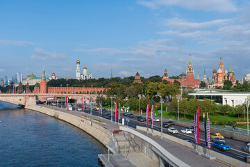 Fototapeta na wymiar Cityscape of Moscow city downtown district. View of Moskvoretskaya embankment located by Moscow Kremlin, Red Square, St. Basil's Cathedral and Zaryadye park. Blurred cars on the road.