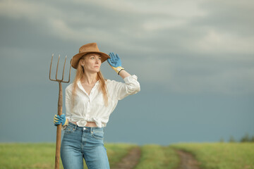 Country woman in field with pitchfork