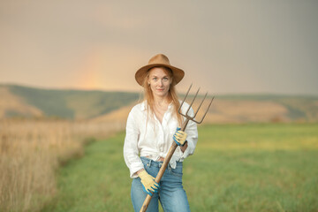 Country woman in field with pitchfork