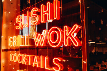 night. neon shining signboard with word sushi wok