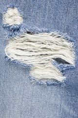 Fototapeta na wymiar Blue torn denim jeans texture.