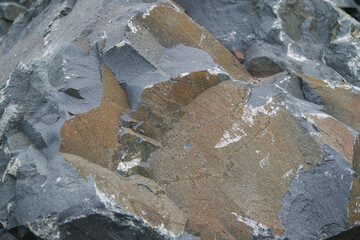 Basalt. Fancy patterns on the rocks. The texture of the stone. Severoonezhsky basalt mine. Arkhangelsk region, Russia.