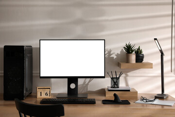 Stylish workplace with modern computer near white wall indoors. Space for text