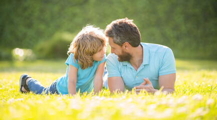 happy family of daddy and son boy relax in summer park green grass, adoption