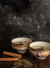 two china cups filled with tea leaves in hot water