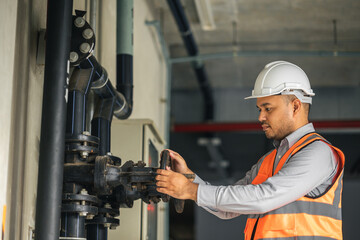 Young asian engineer working at valve water pump checking and maintenance for the safety. Worker...
