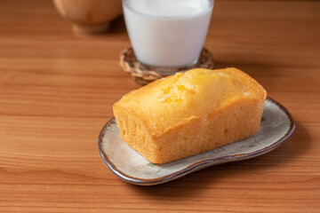 Orange cake with fresh milk on wooden floor
