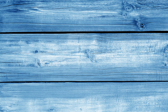 Wall made of uncutted weathered wood boards in navy blue color.
