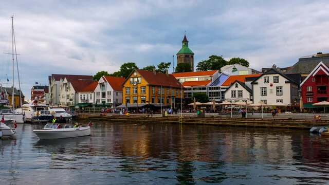 Stavanger, Norway. View of the city center in Stavanger, Norway during a cloudy summer evening. Lively street life with many restaurants and cafes. Time-lapse with people and boats, zoom in