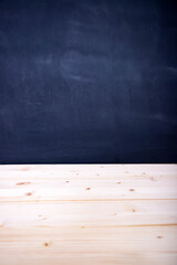 Empty wooden table against a blackboard background