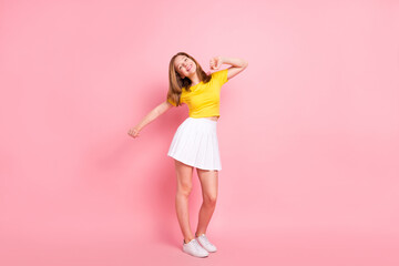 Full length photo of young girl happy positive smile have fun dance music isolated over pink color...