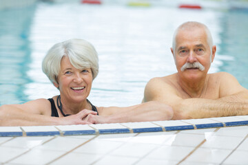 Fototapeta premium happy senior couple swimming in the pool