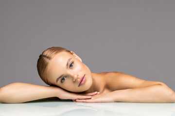 Healthy skin young woman beautiful face close up over gray background
