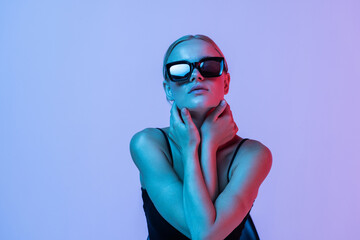 Fashion. Woman in Colorful neon light. Fashionable model portrait in sunglasses creative art neon pink blue light, banner
