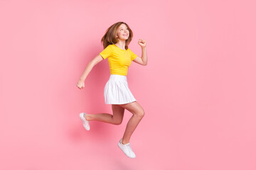 Fototapeta na wymiar Full size profile side photo of young girl happy smile jump up go walk run isolated over pink color background