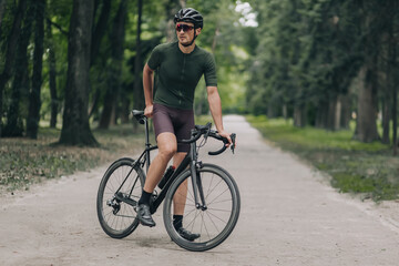 Obraz premium Tired caucasian man relaxing after cycling at city park