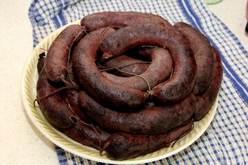 Large plate with boiled homemade blood sausages before baking. Organic blood sausage. Homemade sausages