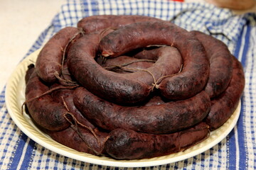 Large plate with boiled homemade blood sausages before baking. Organic blood sausage. Homemade sausages