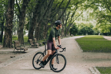 Fototapeta na wymiar Man in sport clothes enjoying morning cycling on fresh air