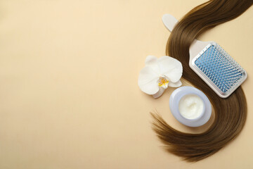 Jar of cosmetic product, orchid flower, brush and hair lock on beige background, flat lay. Space...