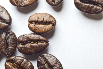 Close-up of coffee beans with details cracked by heat on a white background.