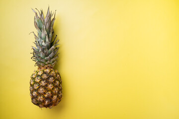 Yellow Pineapple or ananas, on yellow textured summer background, top view flat lay, with copy space for text
