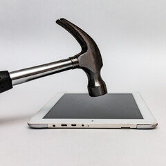 The hammer breaks the tablet computer. Repair of broken glass of the tablet. Close-up.