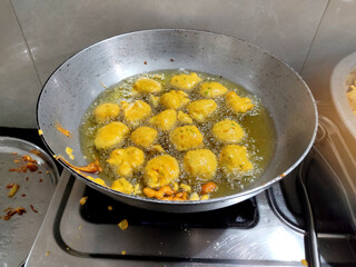 Indian dish Photo of deep frying Methi gota in oil in aluminum kadhai, PAKORA, ALOO BHAJIYA, gram...